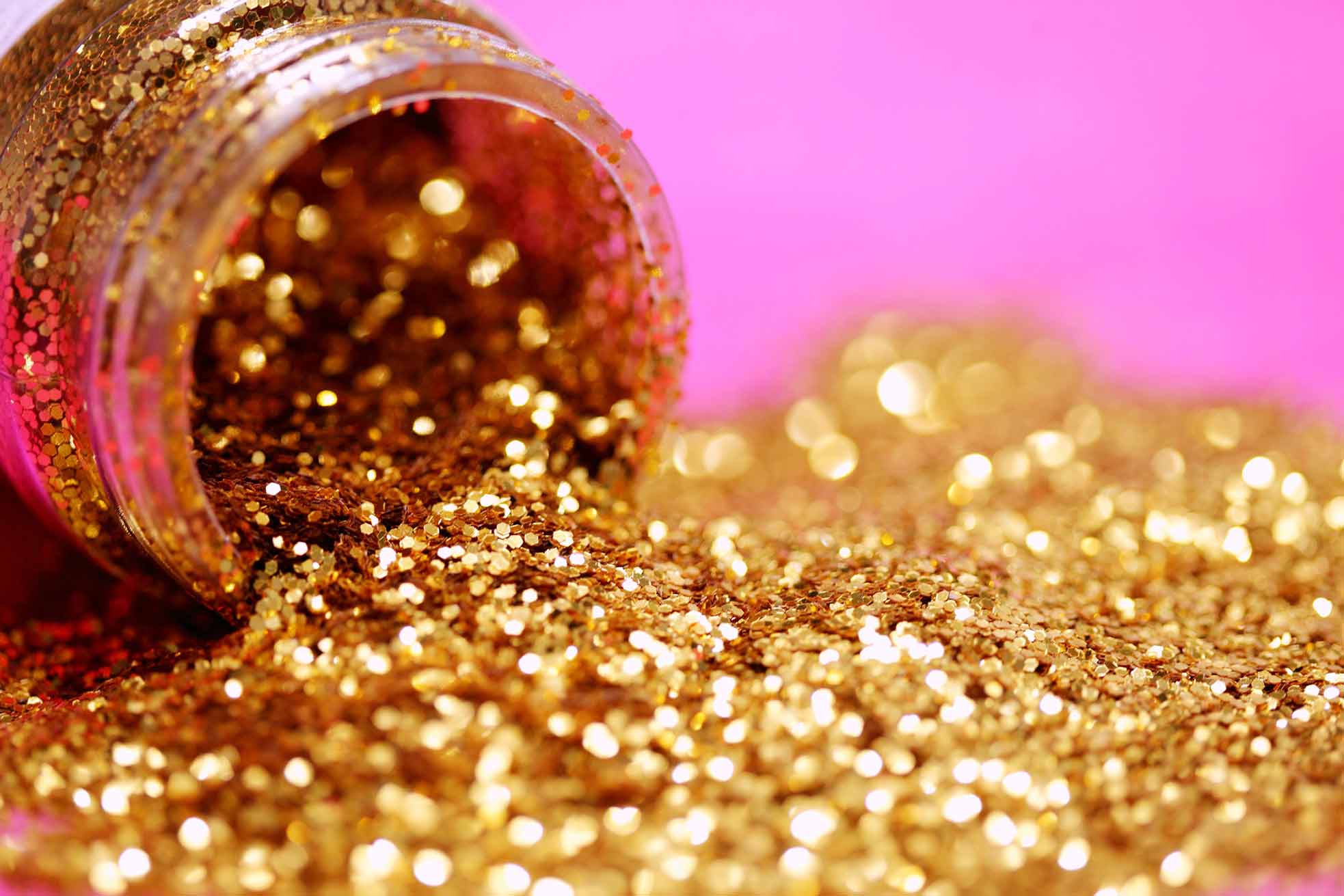 pot of gold glitter spilt over against pink background