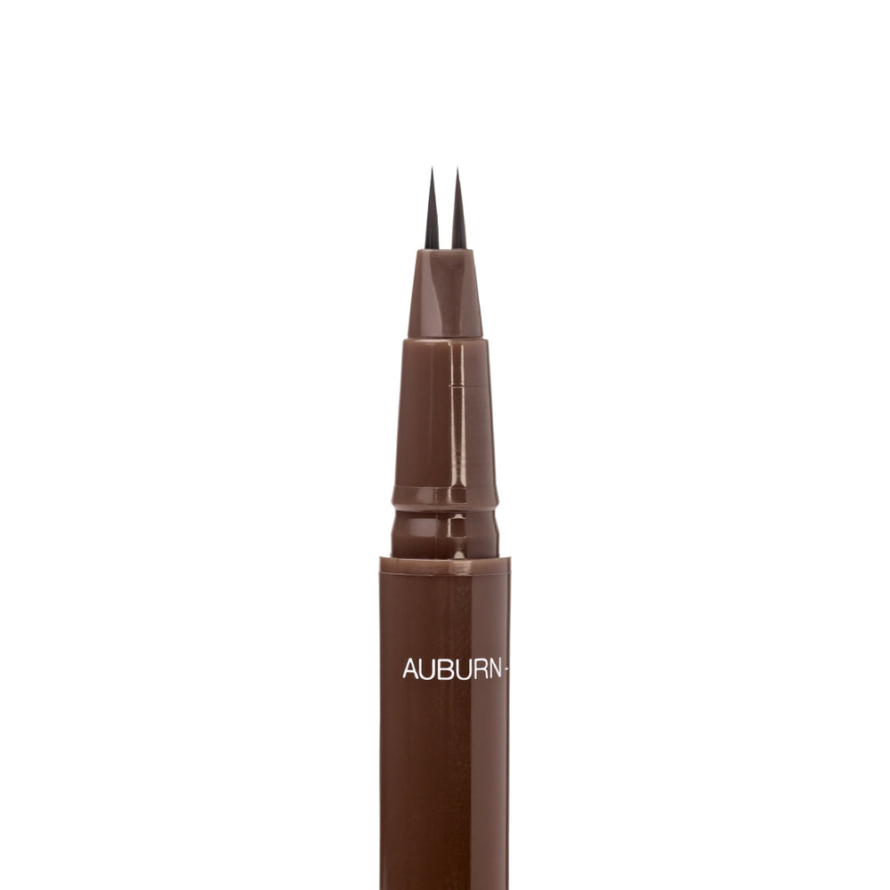 Close-up of the uncapped Palladio Brow Ink Micro Brow Pen in Auburn, showing the fine dual-precision brush tip and the "Auburn" shade label on the barrel.