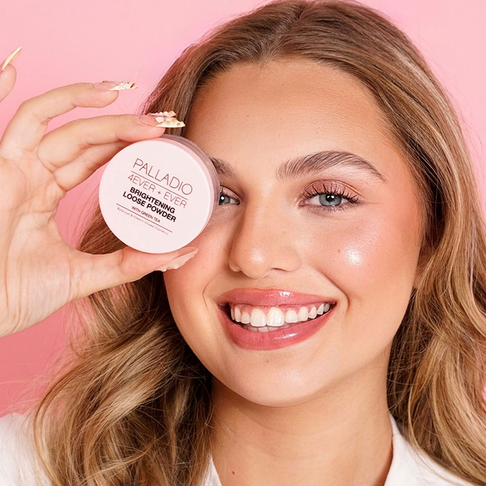 Model holding Palladio 4Ever + Ever Brightening Loose Powder jar in front of her eye, showcasing radiant glowing skin