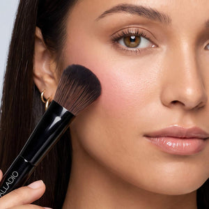 Model applying cheek color with the full blending end of the Palladio Dual Ended Brush.