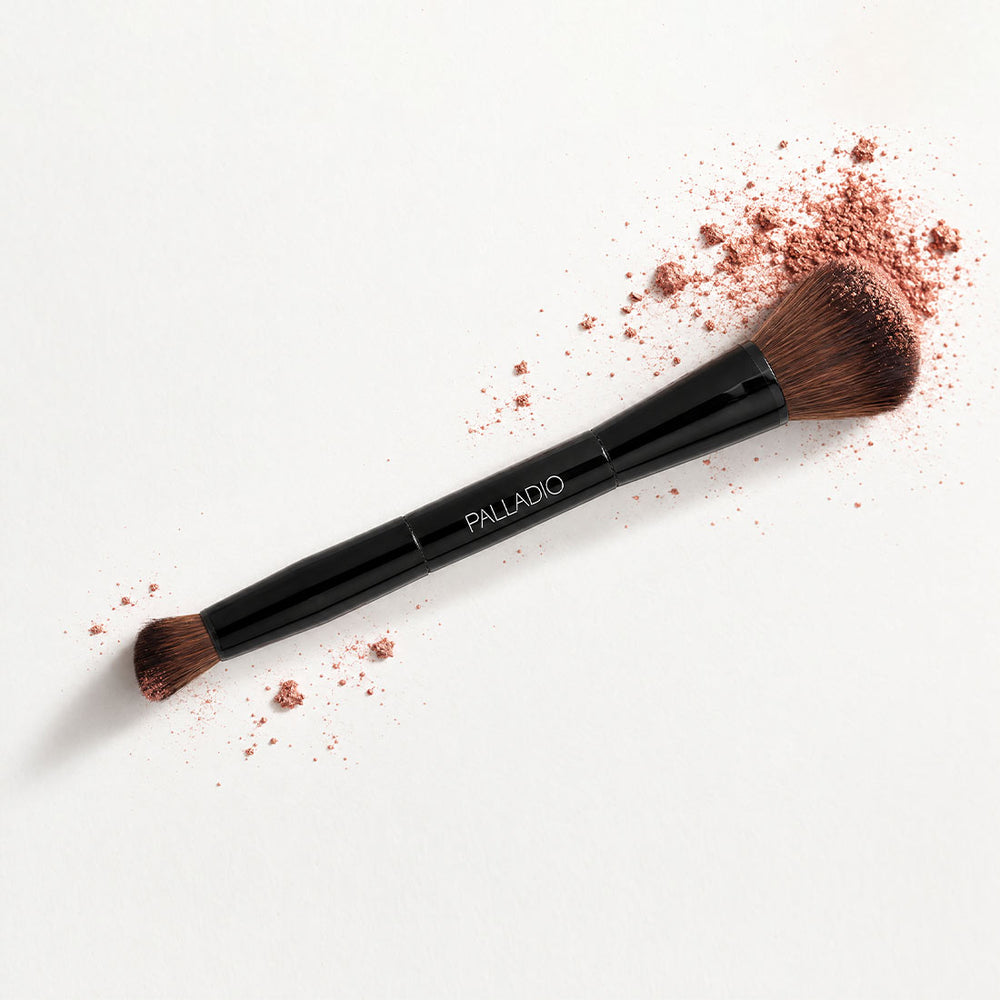Palladio Dual Ended Brush shown diagonally with loose makeup powder around both brush heads.